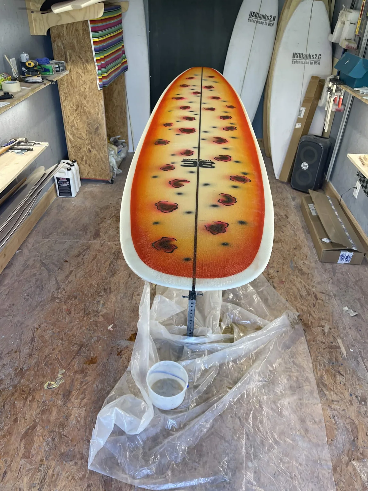 Orange floral custom Third Earth surfboard artwork before final glassing