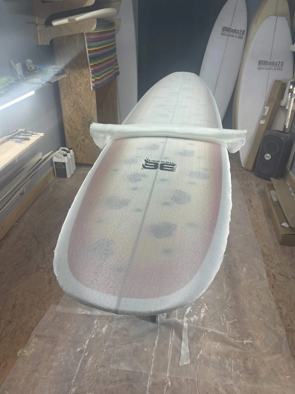 Fiberglass cloth draped over an orange custom surfboard