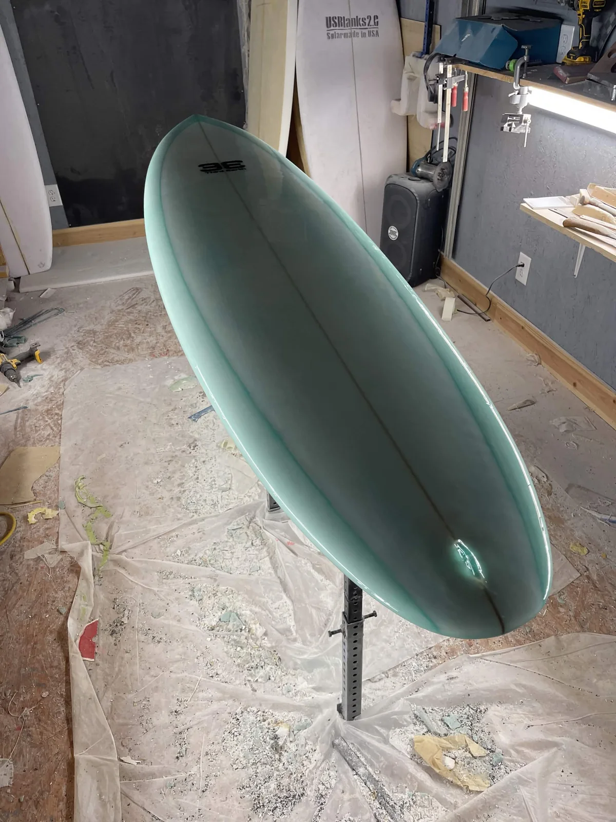 Finished seafoam green Third Earth custom surfboard in the workshop