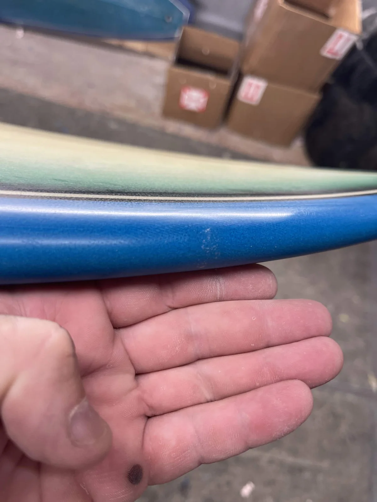 Rebuilt blue surfboard rail blended into the original finish