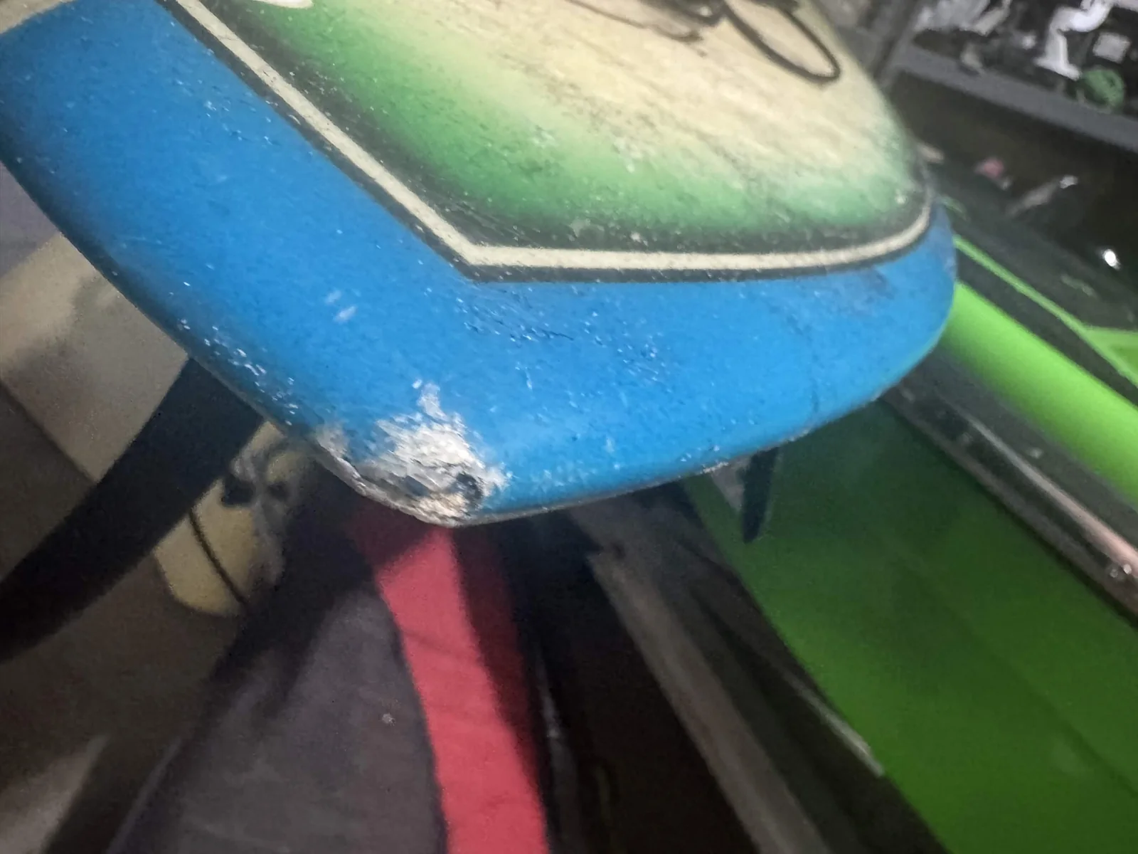 Damaged blue surfboard tail with exposed material