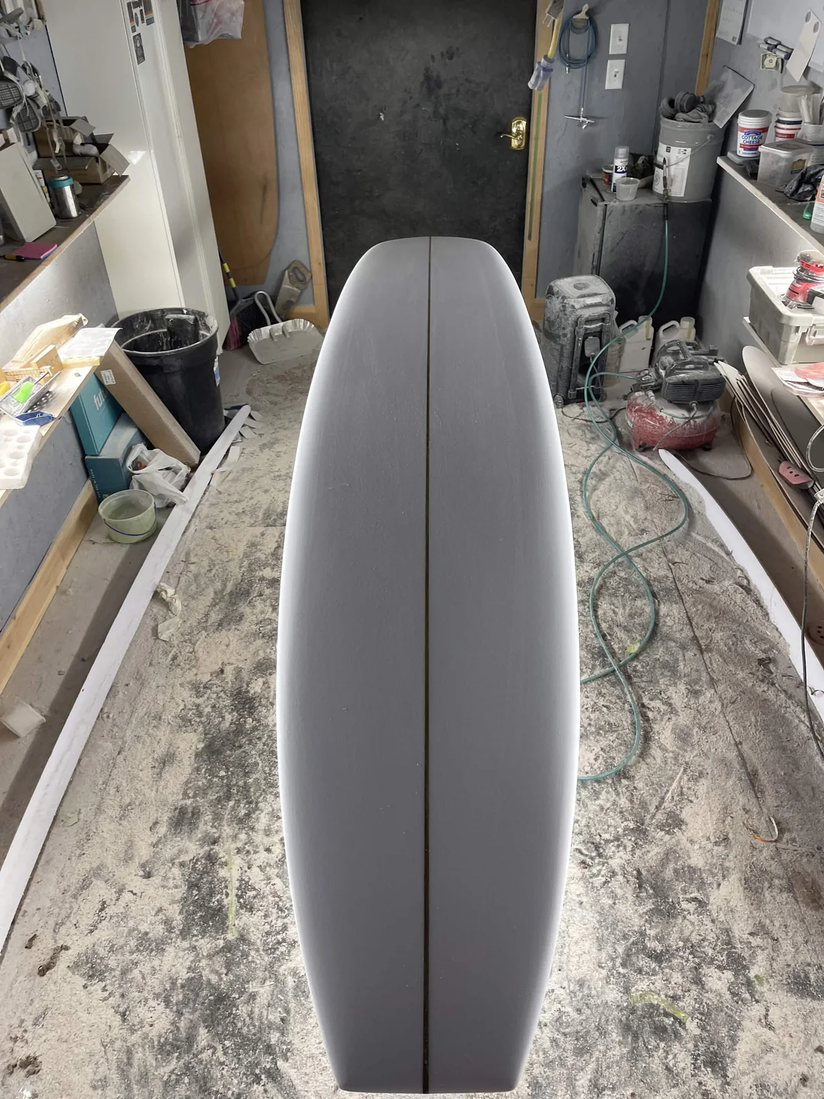 A freshly shaped surfboard foam blank on a shaping stand