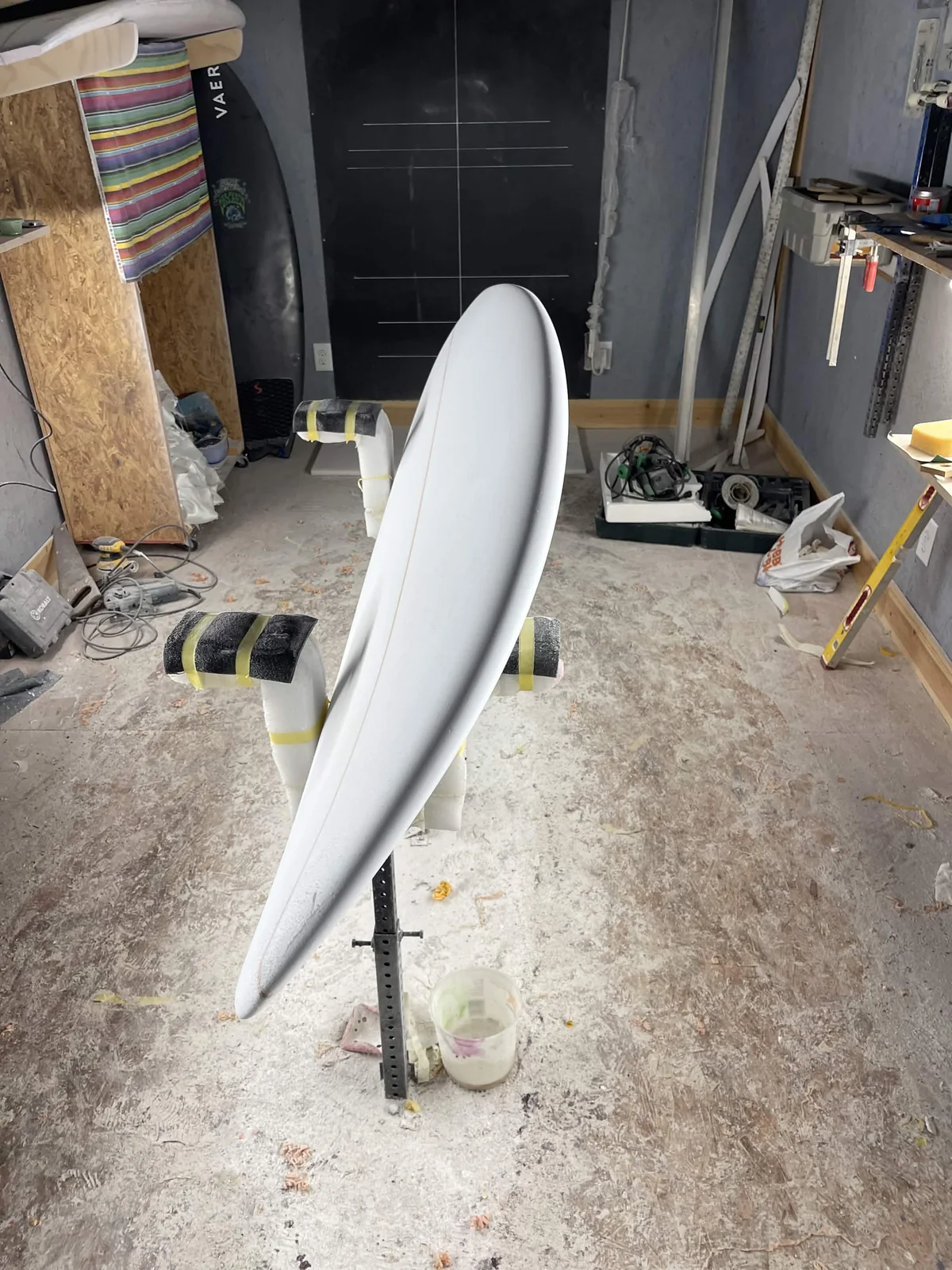 Side profile showing the rail and rocker of a shaped foam surfboard