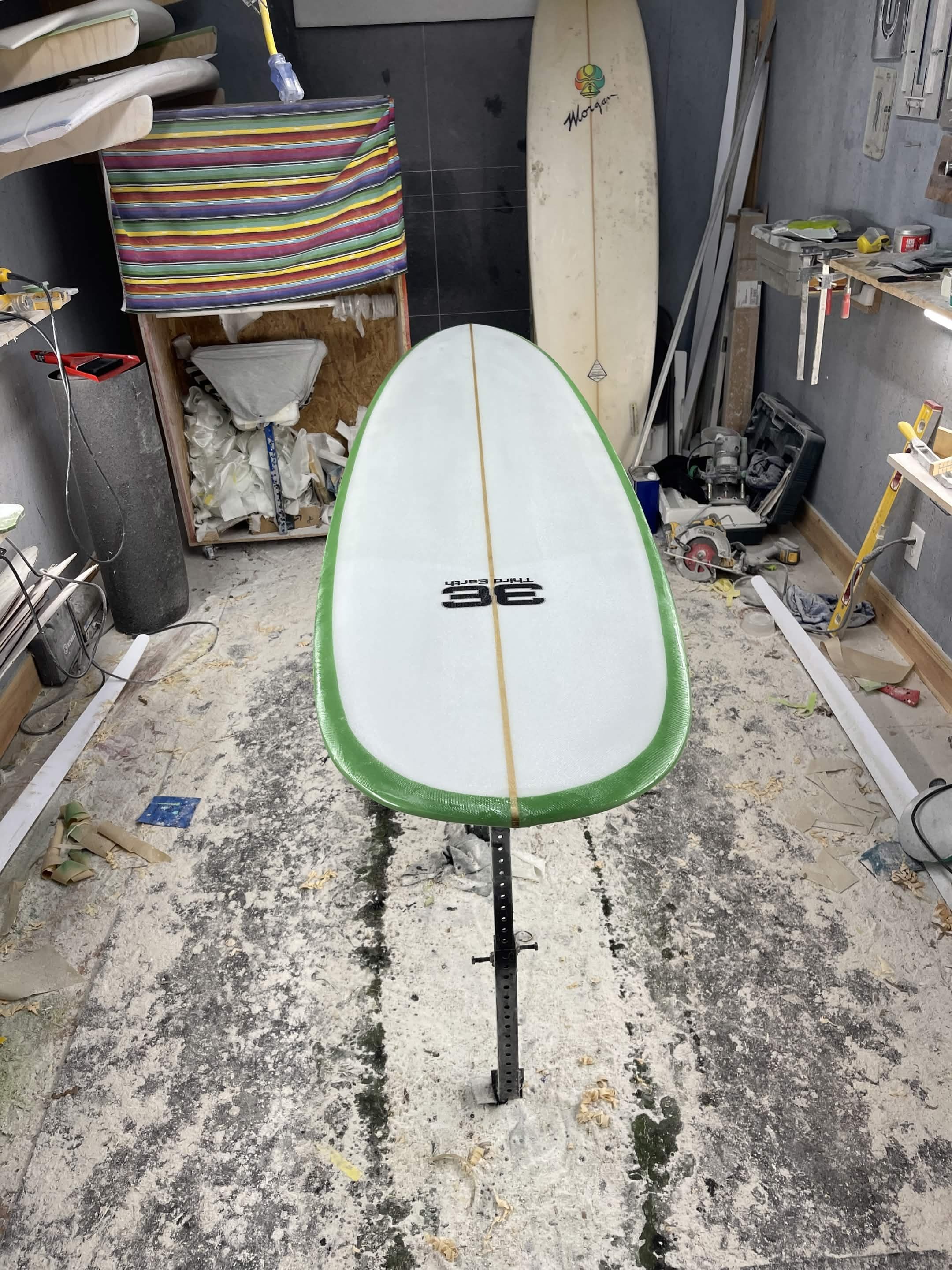 Third Earth surfboard on a shaping stand inside the workshop